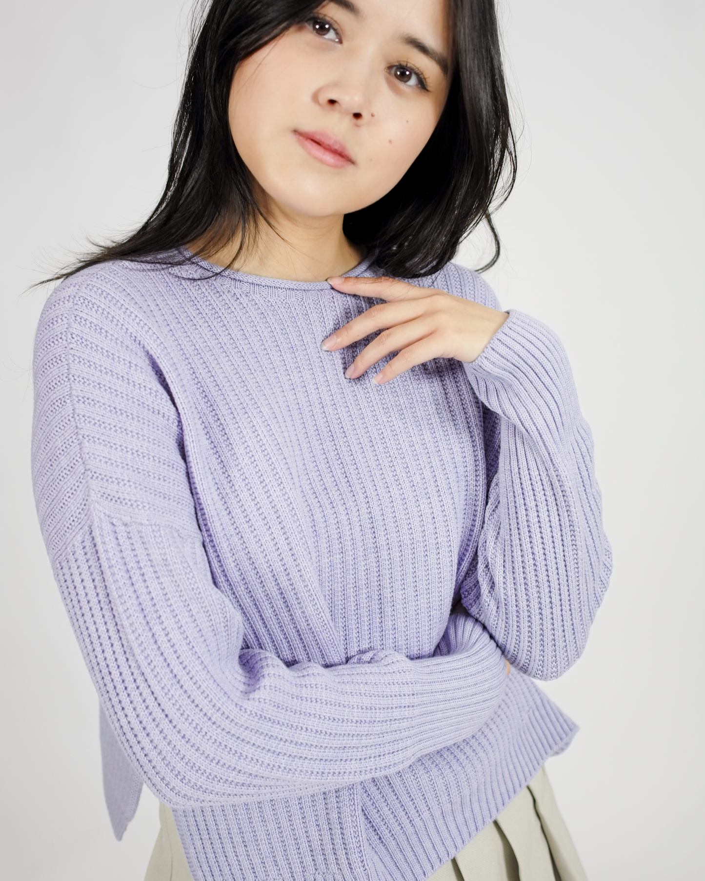 Woman wearing a light purple sweater against a plain background