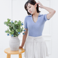 Full-length view of the Corinne cotton knit polo in Cielo blue styled with a white pleated skirt