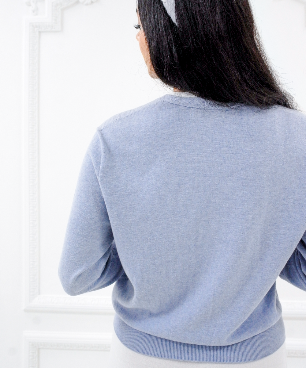 Back view of the Jasmin cotton cardigan in Cielo blue showing its relaxed fit and ribbed hem