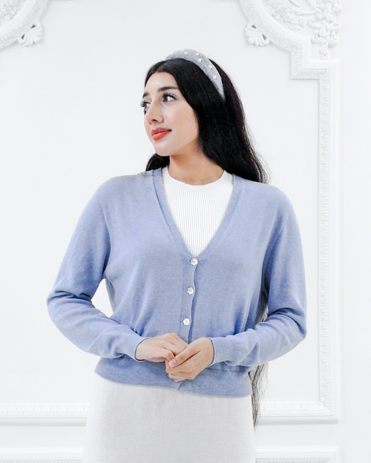 Front view of the Jasmin cotton cardigan in Cielo blue with a V-neckline, long sleeves, and flower buttons
