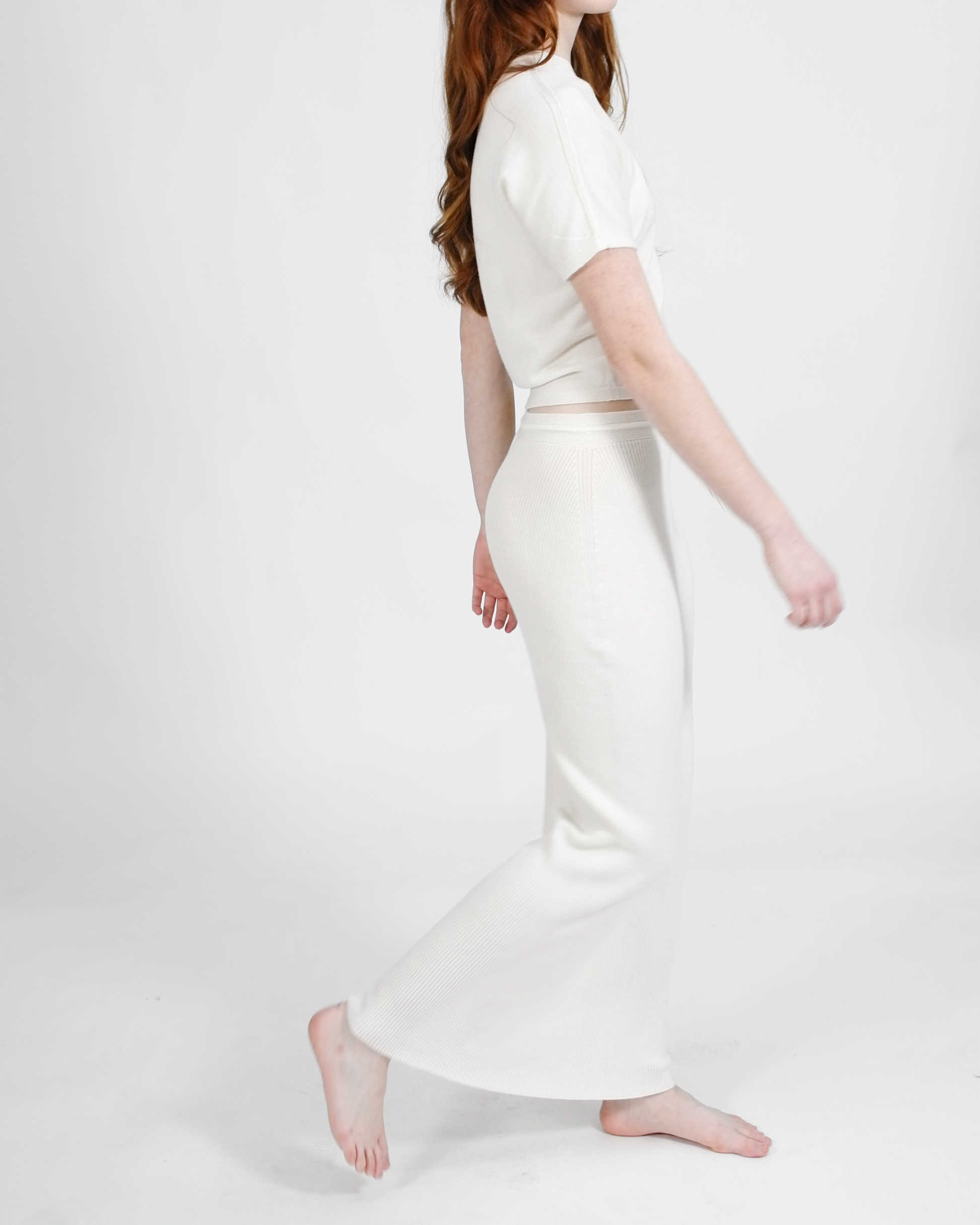 Woman wearing a white outfit on a plain background