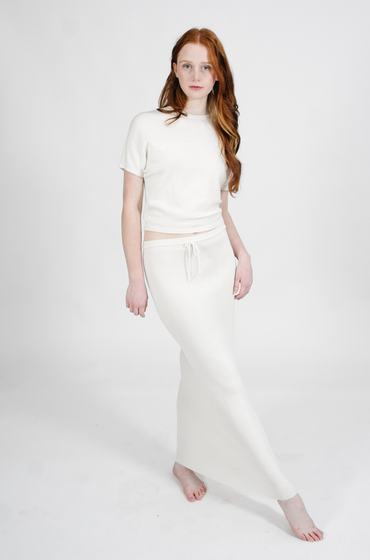 Woman wearing a white outfit on a plain background