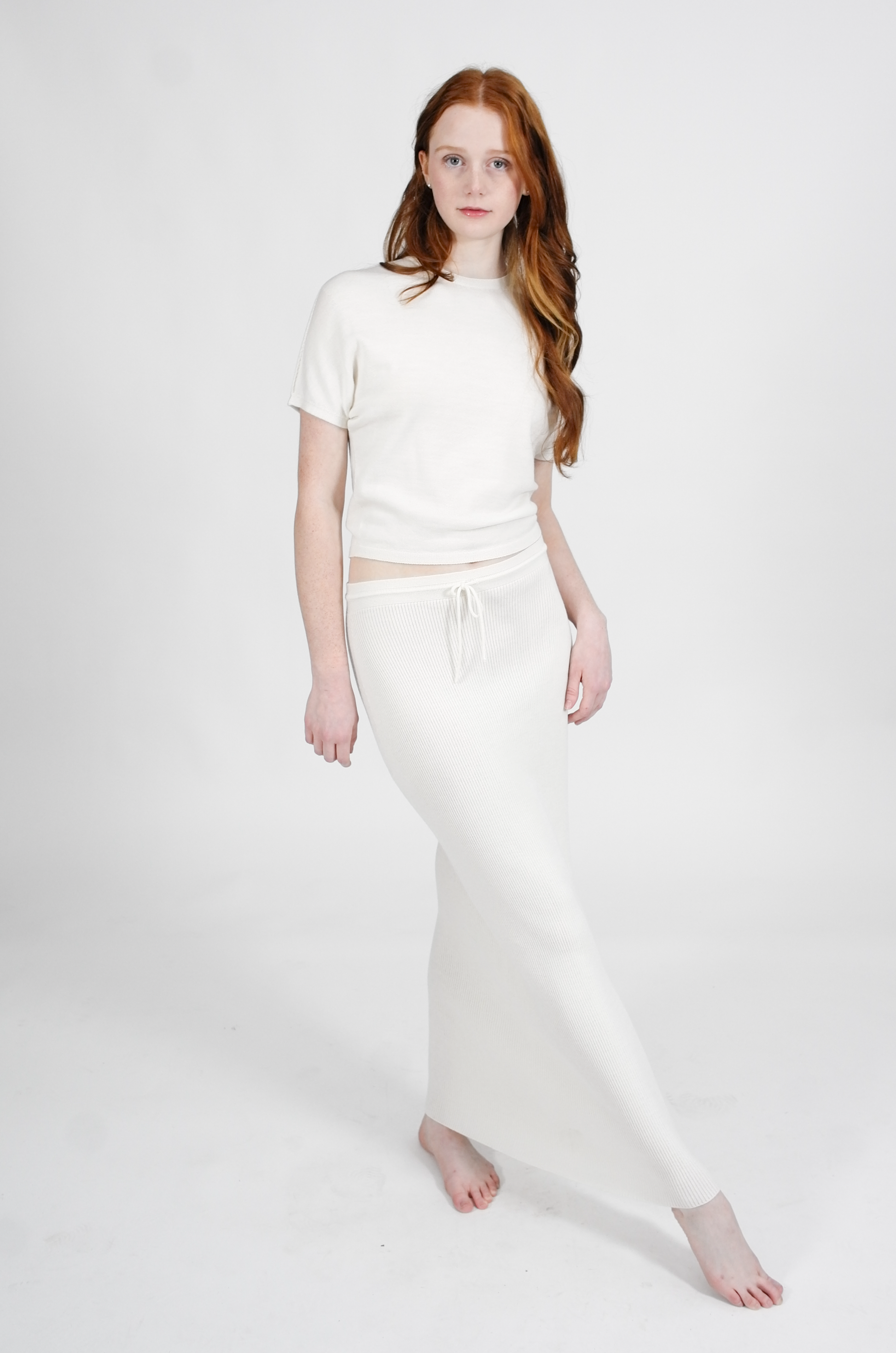 Woman wearing a white outfit on a plain background