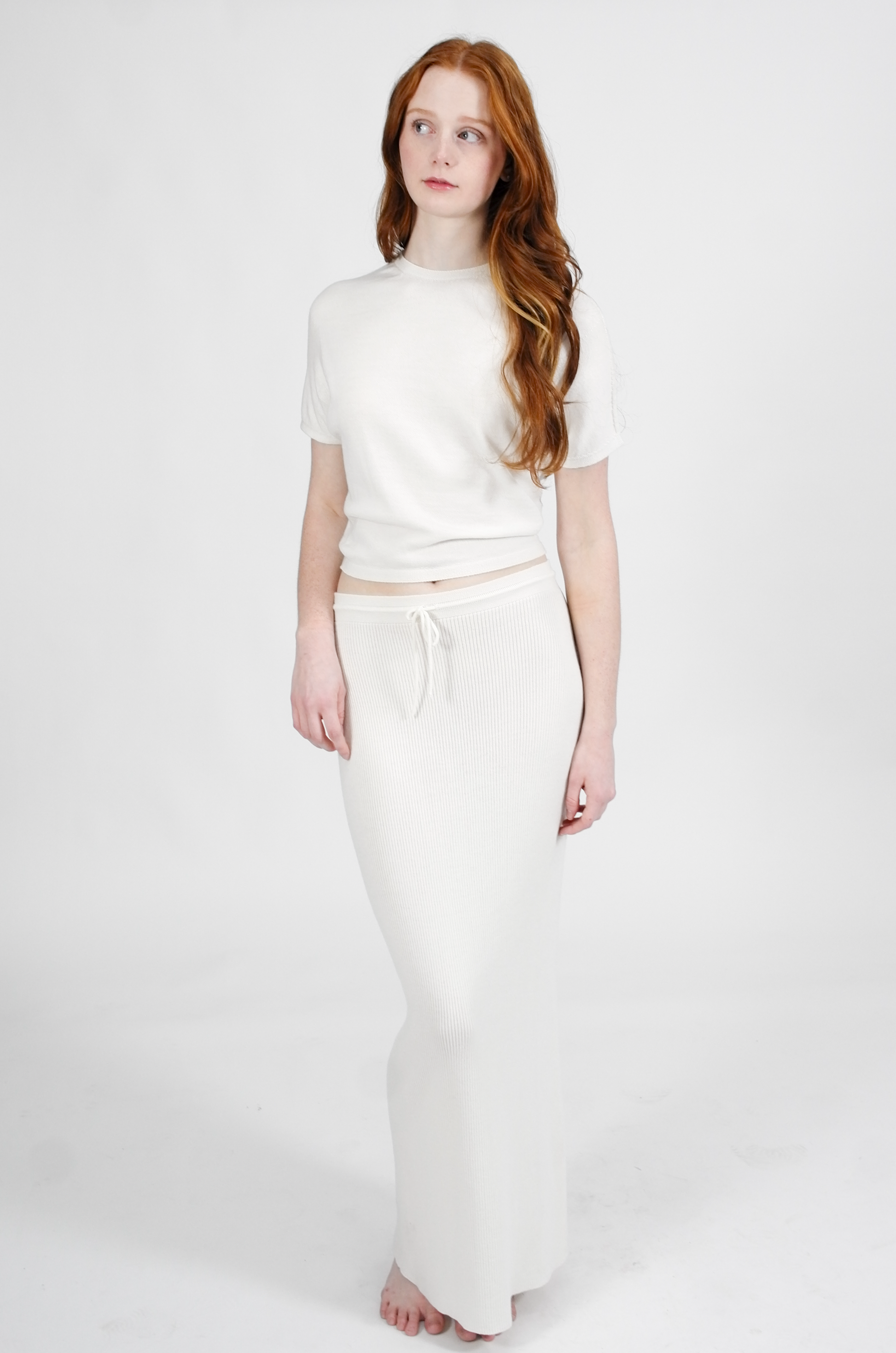 Woman wearing a white outfit on a plain background