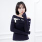 Model wearing the Lisette navy merino off-shoulder top with a white ribbon bow and elongated ribbed cuffs