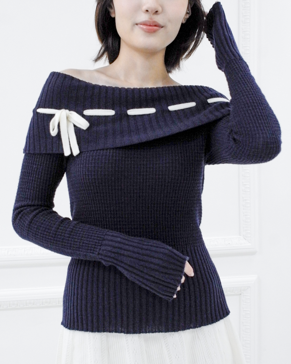 Detail view of the Lisette navy merino off-shoulder top highlighting the waffle knit, ribbed hem, and long cuffs