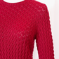 Red pointelle knitted long sleeve sweater on a white background - closeup