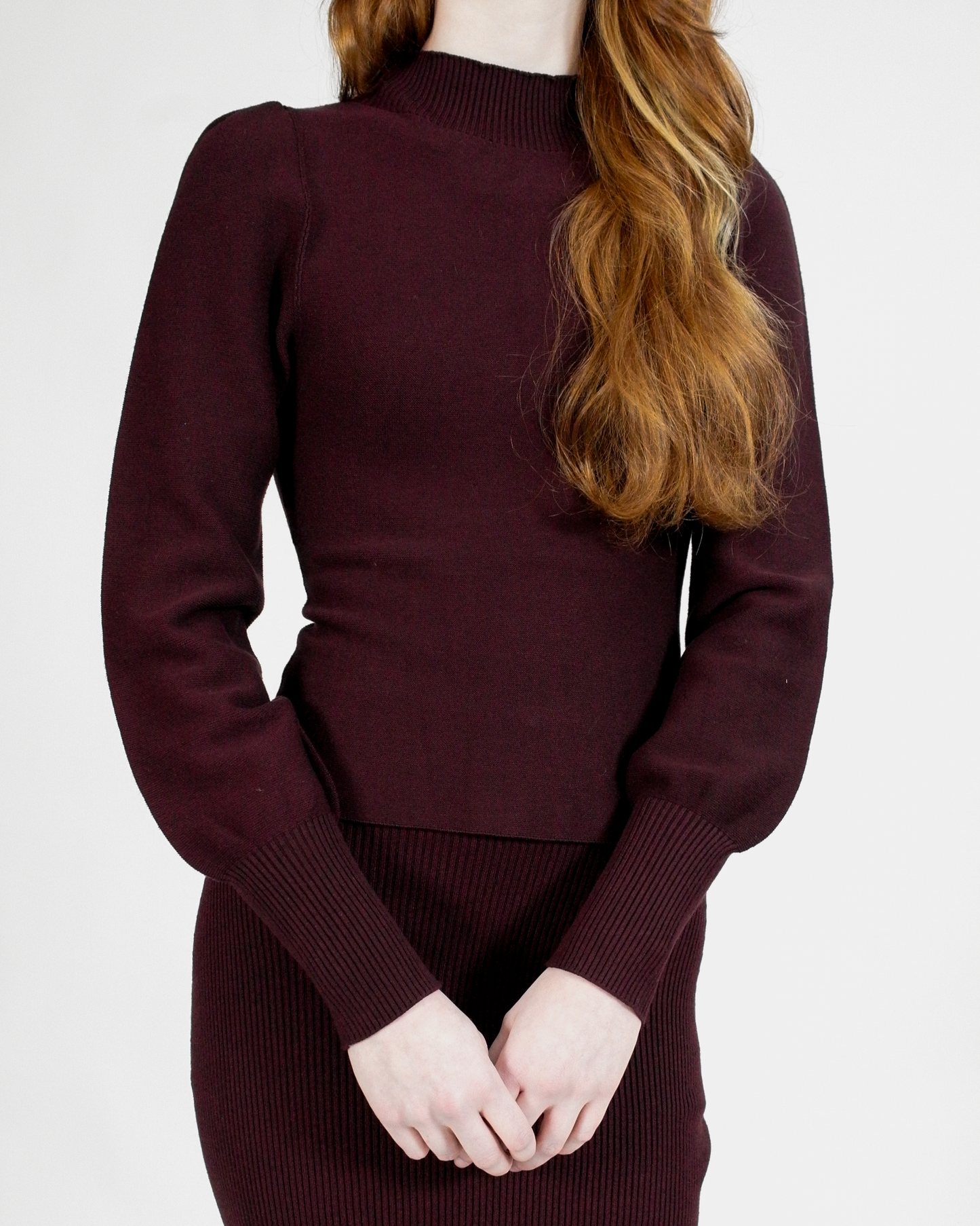 Maroon sweater worn by a person on a white background