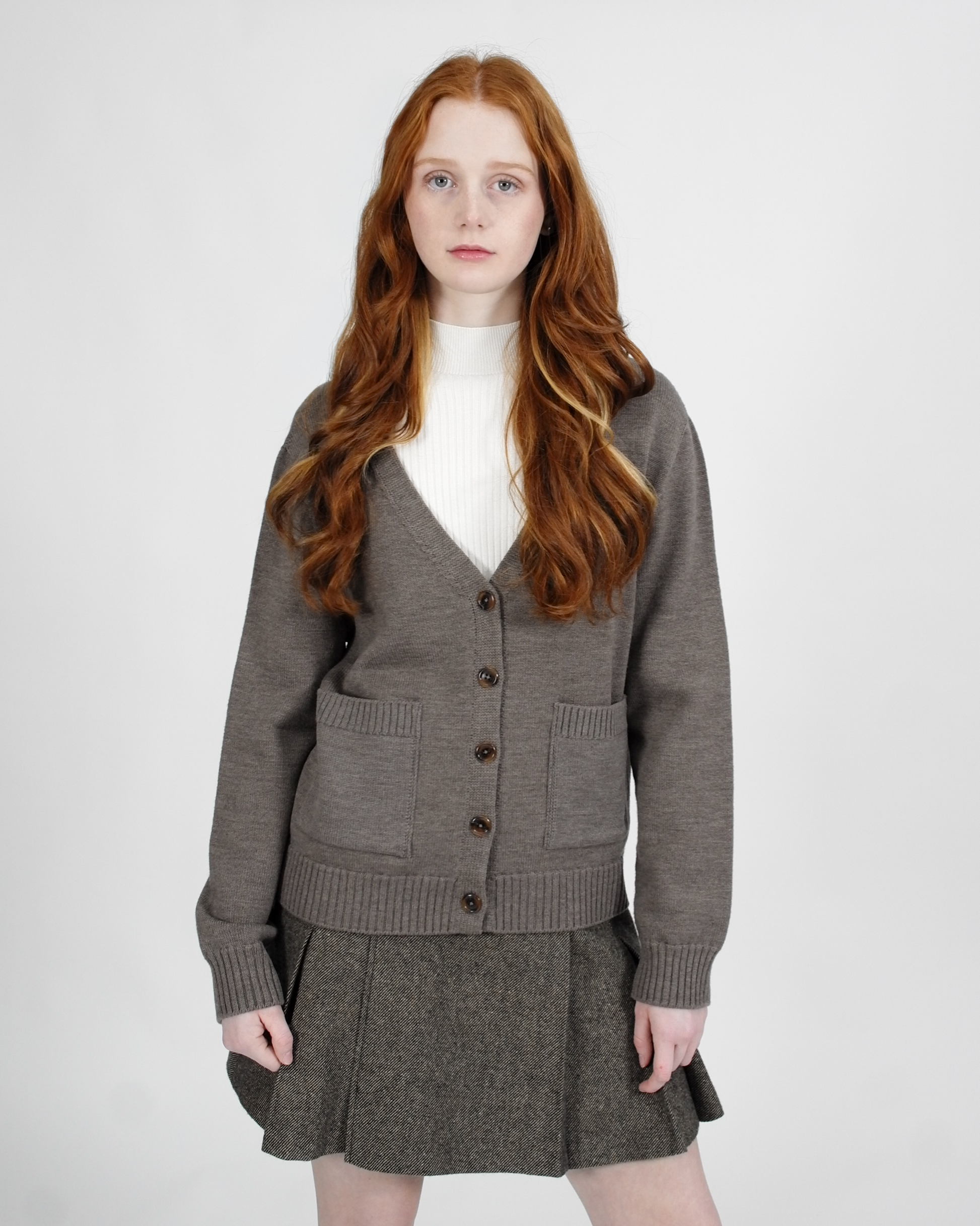 Woman wearing a gray cardigan and skirt set on a white background
