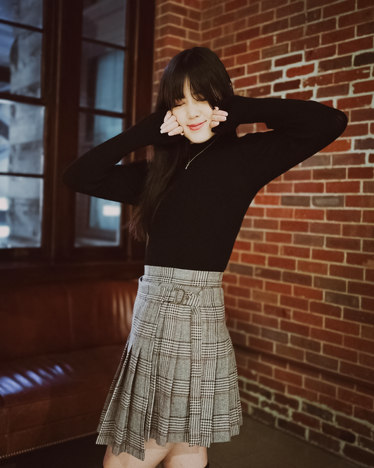 a young woman wearing a black long sleeve Val top and a Sylvie wrap skirt.